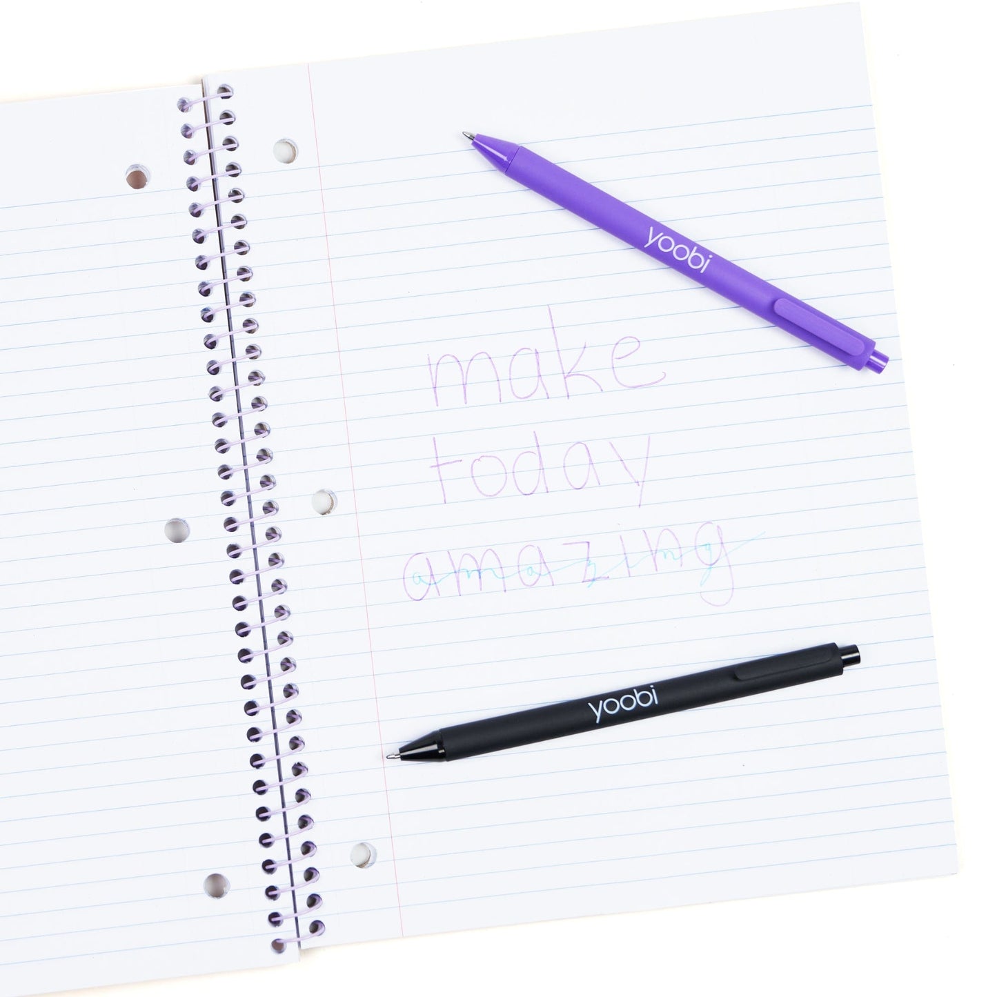 Inside of open one subject spiral notebook showing 3-ring hole punched perforated paper.  Shown with pens